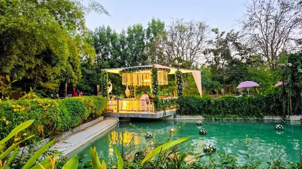 A floral mandap on the lily-pond deck set for a lakeside ceremony