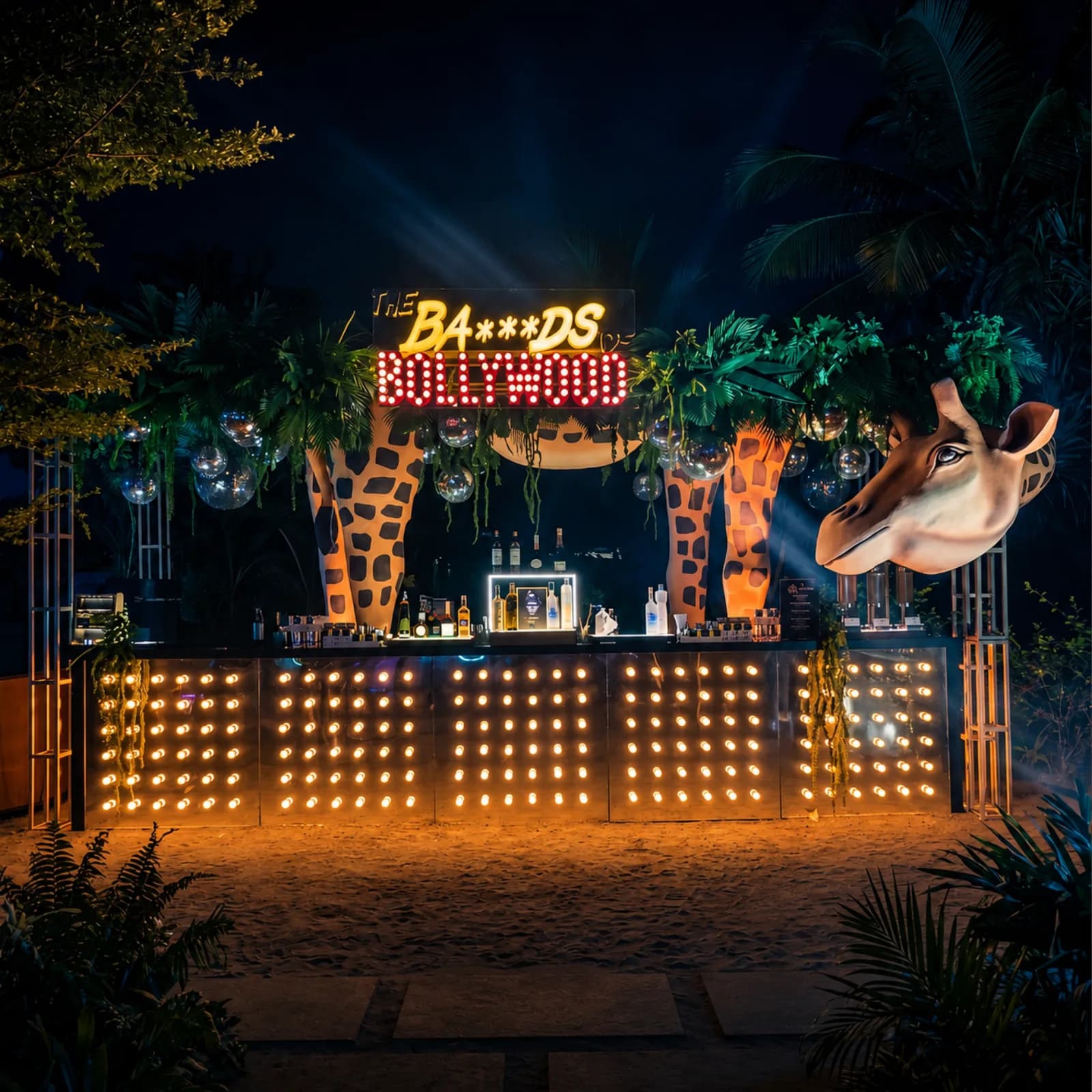 A neon-lit themed cocktail bar dressed with safari decor on the estate at night